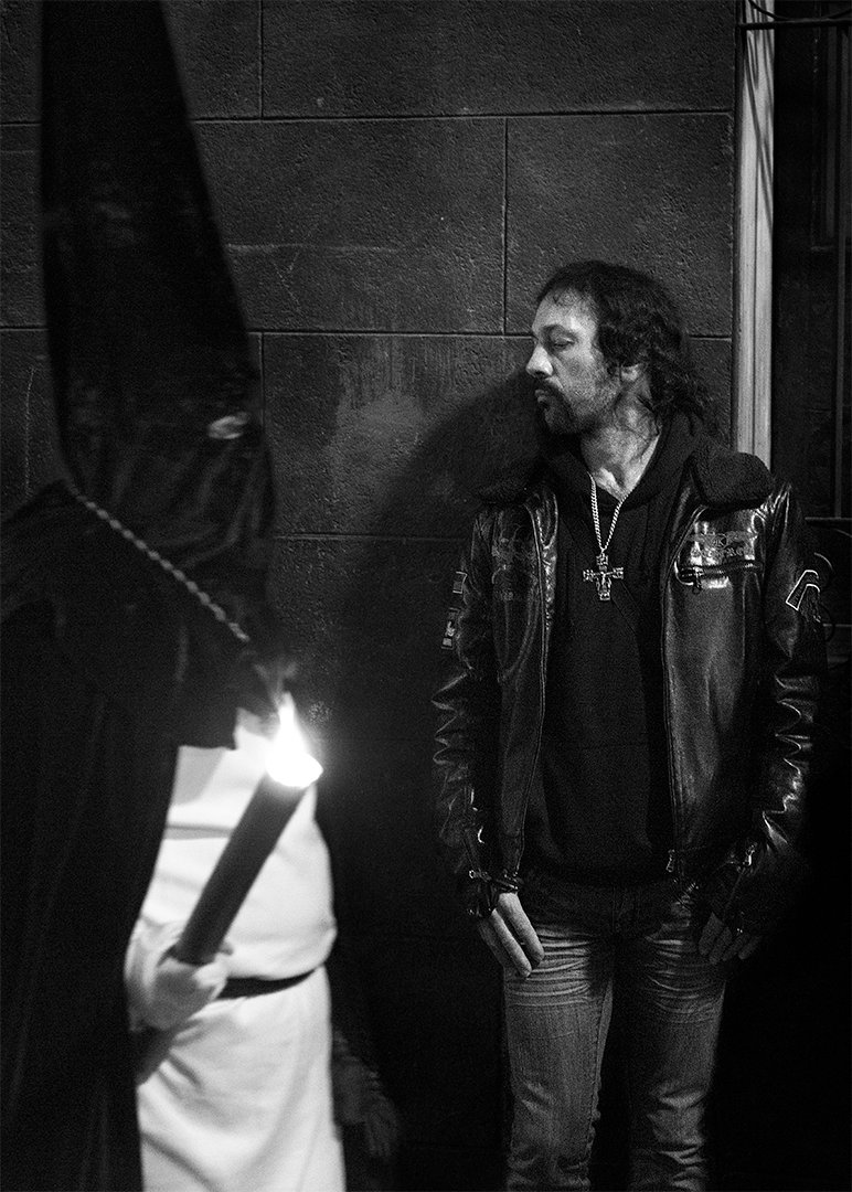 Un hombre en una puerta observa la luz de una calle.